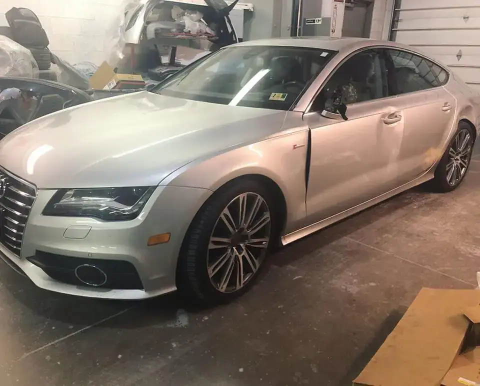 Silver sedan with damaged drivers side door and quarter panel